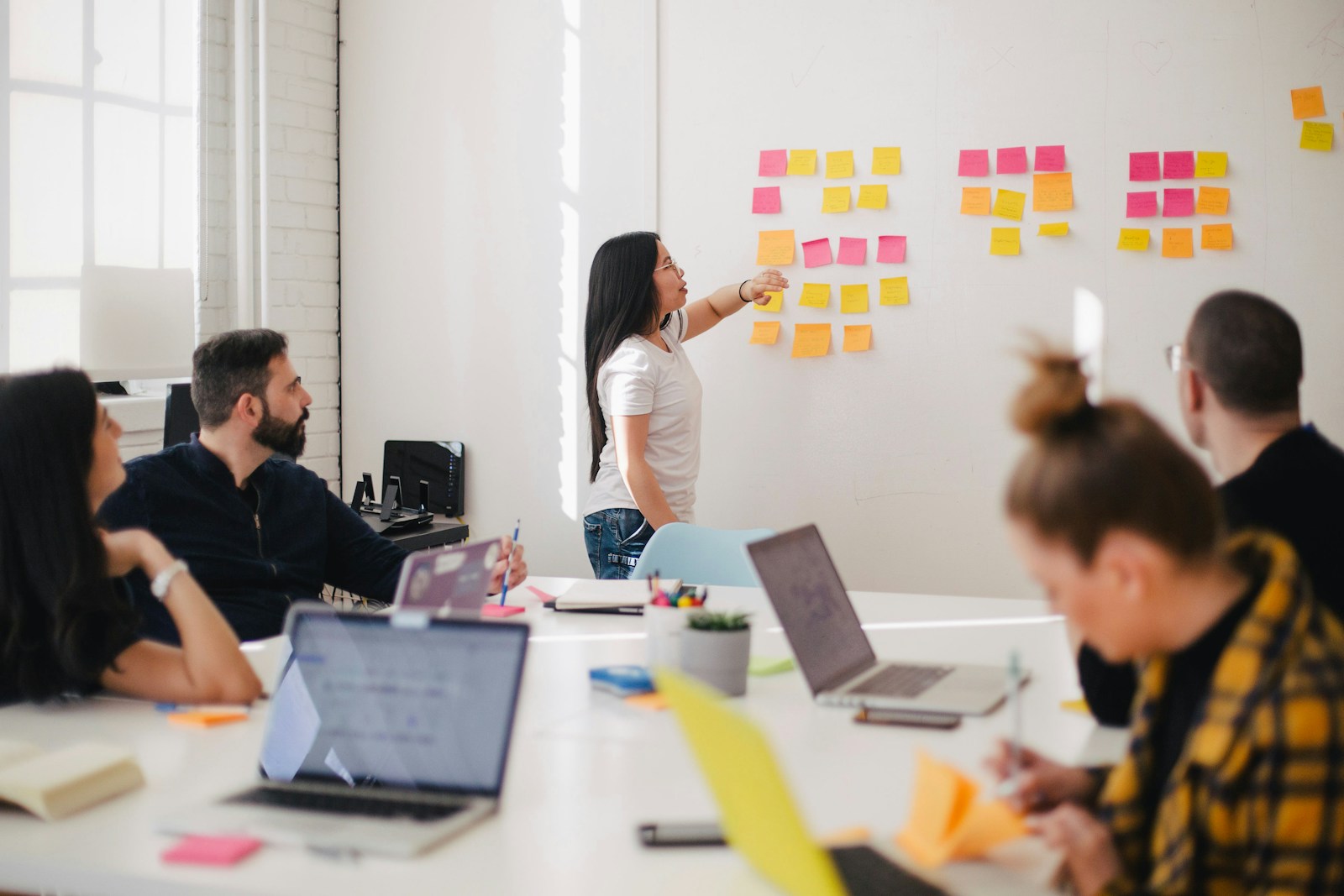 Client workshop with sticky notes mapping launch milestones on a glass wall